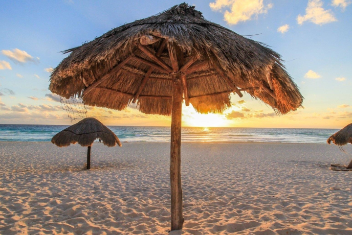 an umbrella sitting on top of a sandy beach